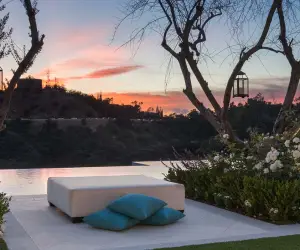 Pool terrace with lounge chairs beside a stone wall